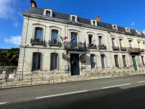 um grande edifício branco com bandeiras ao lado de uma rua em Le St Vincent em Roquefort
