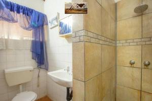 a bathroom with a toilet and a sink at Nag-Apie Vakansiehuis in Marloth Park +44 photos
