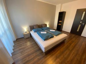 1 dormitorio con 1 cama con almohadas azules en Modern city-center apartment, en Debrecen