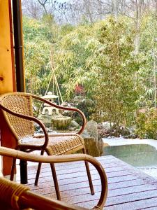 two chairs sitting on a porch with a view of a garden at Private Villa ietona in Fujikawaguchiko
