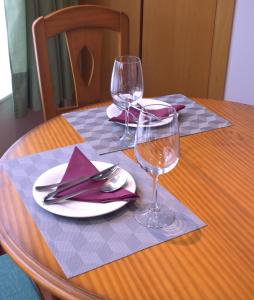 a wooden table with two wine glasses and a table cloth at CAMBARAL 1D in Luarca