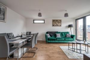 ein Wohnzimmer mit einem grünen Sofa und einem Tisch in der Unterkunft BOYEILLES BELFAST 2 BED MODERN COZY APARTMENT in Belfast