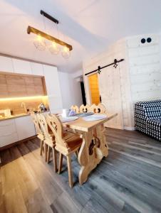 a kitchen with a wooden table and chairs at Rezydencja Pod Giewontem in Zakopane