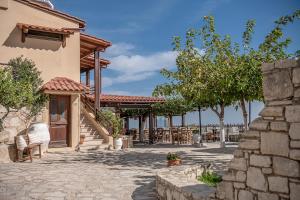 eine Terrasse eines Hauses mit Stühlen und Bäumen in der Unterkunft Earino in Kato Asites