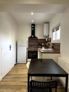奧利韋的住宿－Loiret Luxe Studio，厨房配有黑桌和冰箱。