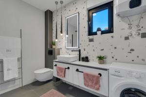 a white bathroom with a sink and a washing machine at Villa Bomada in Tučepi +67 photos
