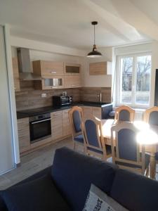 a kitchen with a couch and a table and chairs at location maison vacance in Pouru-Saint-Rémy