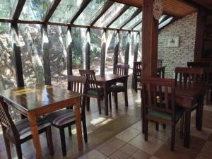 a dining room with wooden tables and chairs at Pássaro de Fogo in Santo Antônio do Pinhal