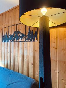 een slaapkamer met een plafondventilator en een blauwe bank bij Superbe studio Morillon Village / Samoëns in Morillon