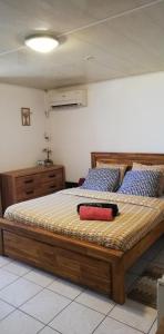 a bedroom with a large bed with a wooden frame at La CAZ A NOU in Saint-Pierre