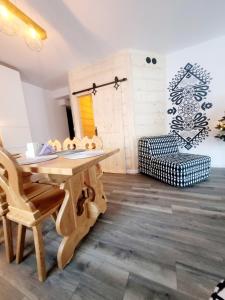 a dining room with a wooden table and a chair at Rezydencja Pod Giewontem in Zakopane