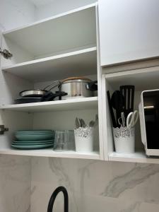 a white cabinet with dishes and utensils in it at Tamarindo 5 in Benalmádena