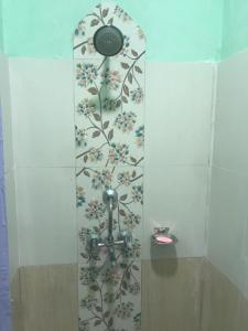 a shower with a flower pattern on the wall at Little Heaven Restaurant & Guesthouse in Deorāli