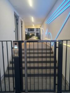 a stairway with a railing and a staircase with blue lights at Chopin airport Apartment in Warsaw