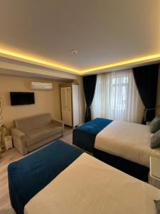 a hotel room with two beds and a couch at Constantinopolis Hotel in Istanbul