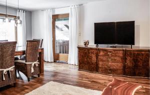 a living room with a television on a wooden dresser at Stunning Apartment In Dorfgastein With Kitchen 