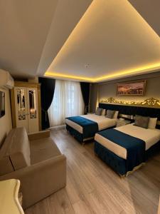 a hotel room with two beds and a couch at Constantinopolis Hotel in Istanbul