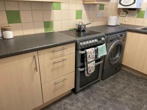 a kitchen with a stove and a washing machine at Barleyfields. Entire House 4 beds 2 baths in Audley