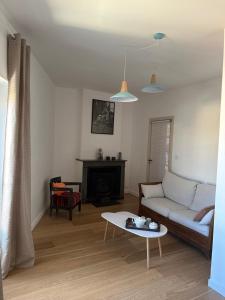 ein Wohnzimmer mit einem Sofa und einem Tisch in der Unterkunft Cocon lumineux T3 proche de Lyon, facile d'accès in Saint-Fons