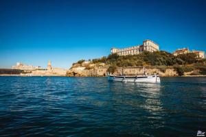 una barca in acqua con una città sullo sfondo di Appart splendide Au Soleil à 2 pas Vieux-Port a Marsiglia