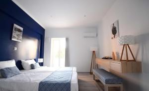 MyrtiesにあるAphrodite Studios Kalymnosの青い壁のベッドルーム1室(ベッド1台付)
