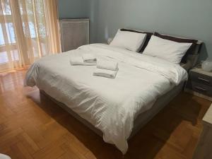 a large white bed with two towels on it at Modern Home in Thessaloniki