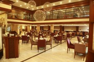 Un comedor con mesas y sillas en un restaurante. en Ramada by Wyndham Multan, en Multán 89 fotos más