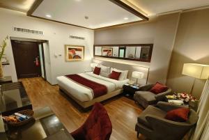 a hotel room with a bed and a living room at Ramada by Wyndham Multan in Multan
