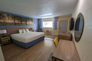 a hotel room with a bed and a television at Days Inn by Wyndham Gainesville University in Gainesville