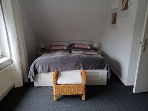 a small bedroom with a bed and a chair at Familienzimmer HH-Schnelsen in Hamburg