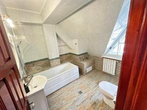 La salle de bains est pourvue d'une baignoire, de toilettes et d'un lavabo. dans l'établissement Pine Peak Apartments, à Predeal