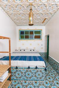 a bedroom with a bed with a blue and white ceiling at Colorful traditional Riad w/views of Spain in Tangier