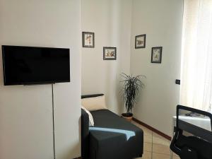 sala de estar con TV de pantalla plana en la pared en Holiday Apartment - Brescia centro - PARCHEGGIO PRIVATO en Brescia