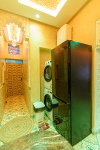 a kitchen with a refrigerator and a washing machine at Colorful traditional Riad w/views of Spain in Tangier