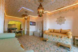 Colorful traditional Riad w/views of Spain في طنجة: غرفة معيشة مع أريكة وطاولة