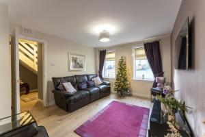 ein Wohnzimmer mit einem Ledersofa und einem Weihnachtsbaum in der Unterkunft Iona in Stirling