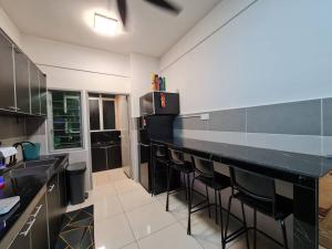 een keuken met een zwarte bar met krukken bij Homestay Epoh Meru Raya F3 with Netflix in Ipoh