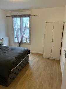 a bedroom with a bed and a large window at Appt spacieux et calme prox Disney-CDG-Stade de France in Le Blanc-Mesnil +10 photos