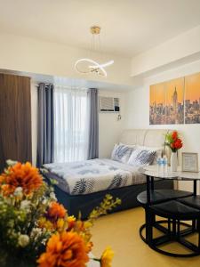um pequeno quarto com uma cama e uma mesa em City View Studio Unit at Centrio Tower beside Ayala Mall em Cagayan de Oro