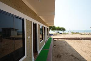 un bâtiment avec un trottoir verdoyant à côté de la plage dans l'établissement Borrbo Beach Hostel Gokarna, à Gokarna