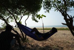 - une femme se coucher dans un hamac sur la plage dans l'établissement Borrbo Beach Hostel Gokarna, à Gokarna
