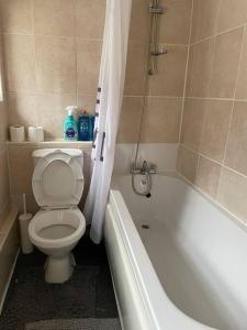 a bathroom with a toilet and a tub and a sink at Keary Entire House. 3 beds. Bright and Cheerful. in Stoke on Trent
