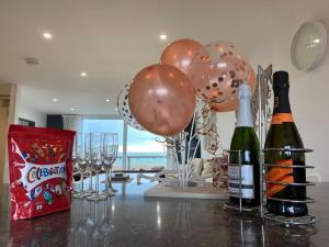 a table with balloons and wine bottles and glasses at Horizon View in South Hayling