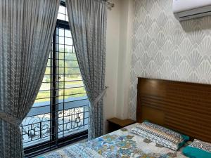 a bedroom with a bed and a large window at Dream Plaza in Gujrānwāla