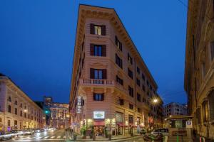 Un palazzo alto in una strada di città di notte di Cosmopolita Hotel Rome, Tapestry Collection by Hilton a Roma