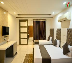ein Hotelzimmer mit 2 Betten und einem TV in der Unterkunft Hotel MY Dream in Aligarh