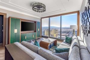 a living room with a large couch and a large window at Hilton Club Elara Las Vegas in Las Vegas