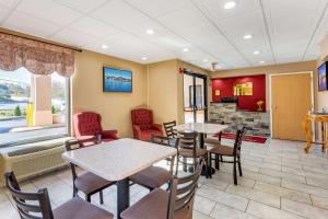 a waiting room with tables and chairs and a fireplace at Econo Lodge Lookout Mountain in Chattanooga