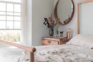 a bedroom with a bed and a mirror at Boutique Beach Retreat in Westward Ho