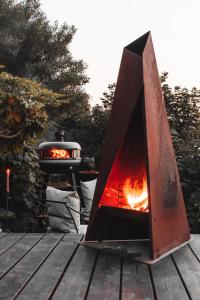 a fireplace on a wooden deck with two fires at Boutique Beach Retreat in Westward Ho